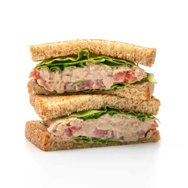 Stacked tuna salad sandwich halves with lettuce and tomato on toasted bread, a Perry Street Grill diner classic.